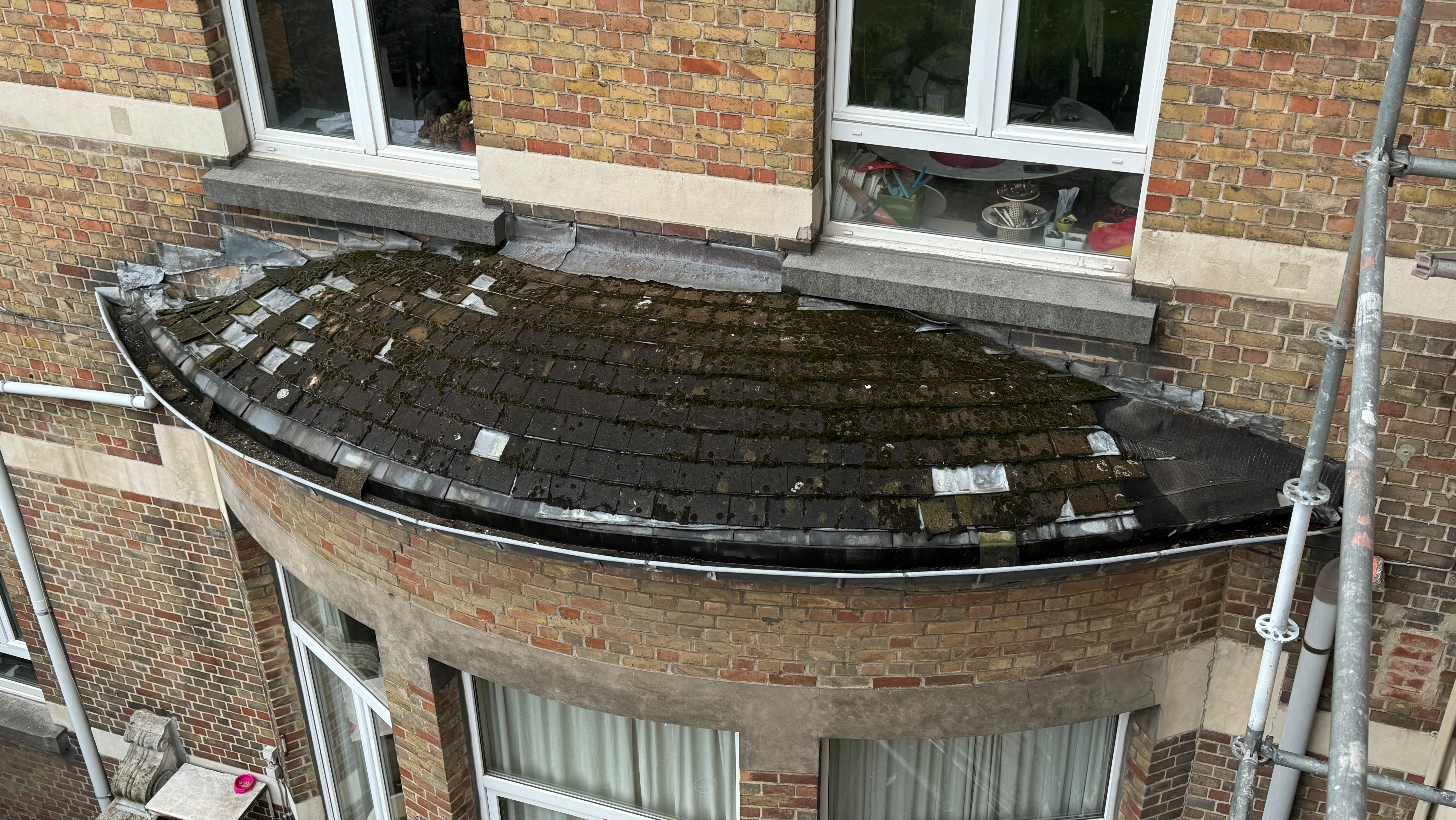 Appentis en ardoises qui présente des signes avancés d'infiltrations