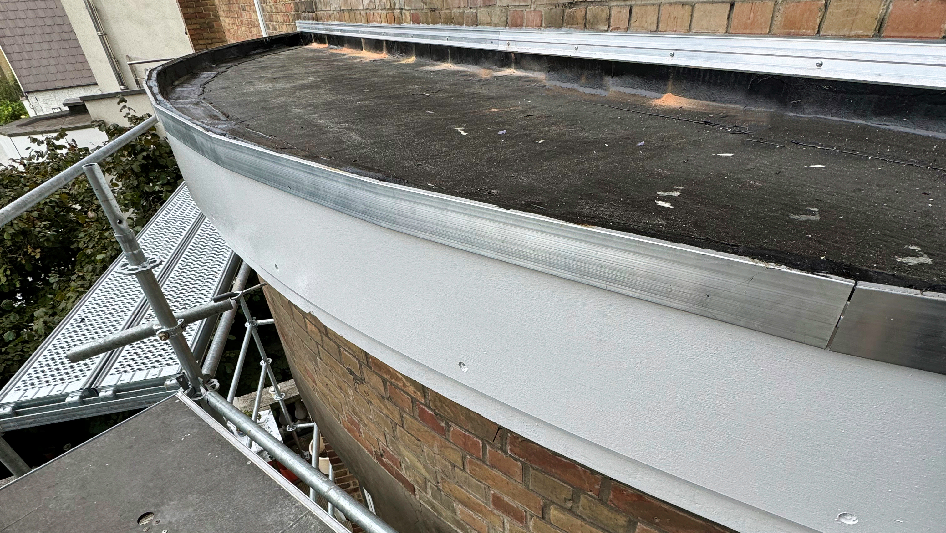 petite toiture avec étanchéité bitumeuse et planche de rive peinte en blanc